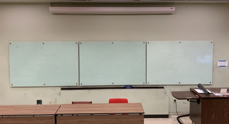 Photo of a classroom with three white boards