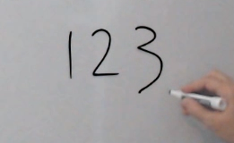 Photo of a hand that wrote 123 on a whiteboard