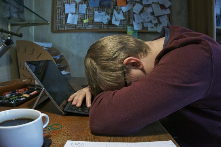 Photo of a student sleeping on his laptop