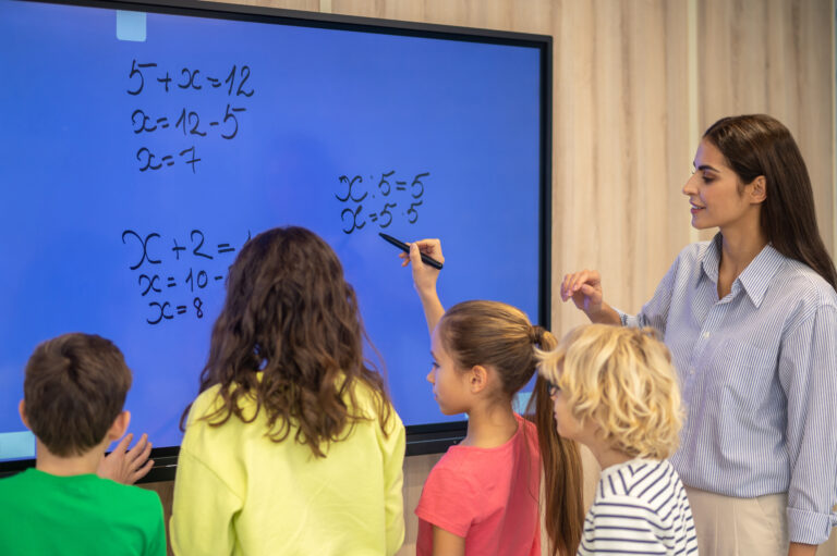 Teachers with students are using digital board.