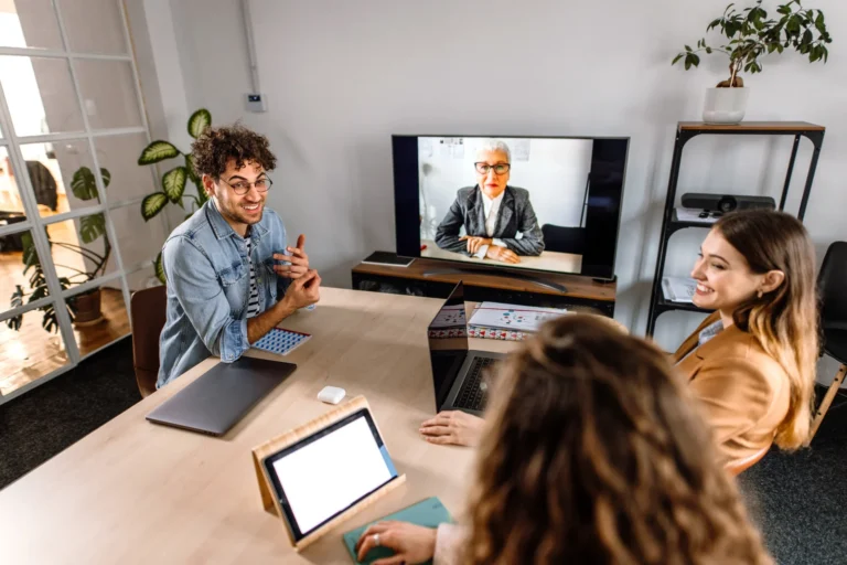 people in office collaborating with remote employee