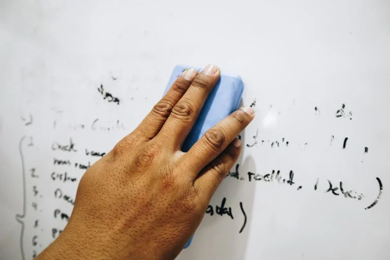 hand of a man erasing the whiteboard